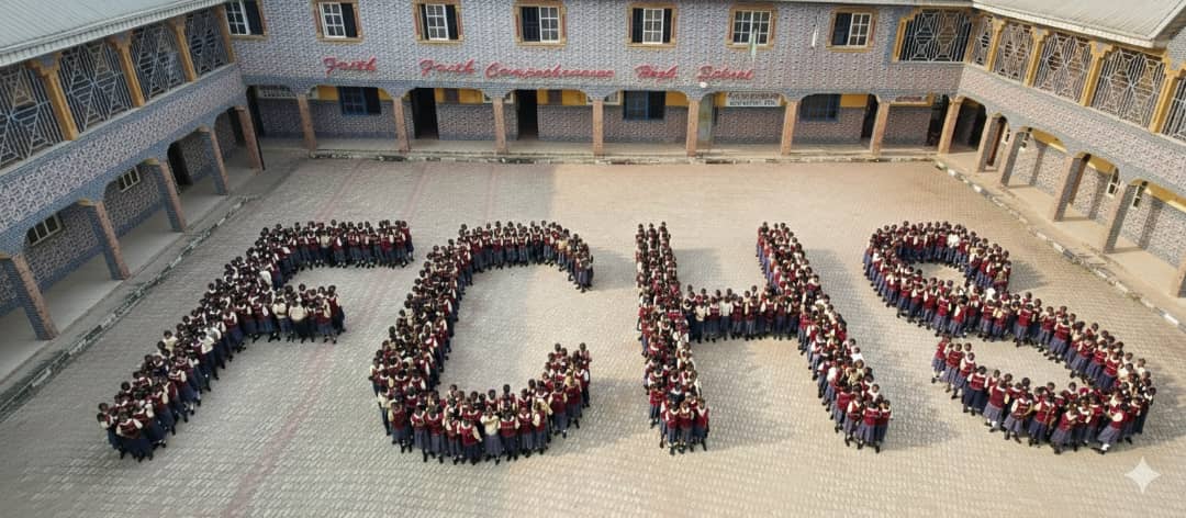 Aerial view of the Faith Comprehensive High School courtyard, with hundreds of students standing in formation to spell FCHS