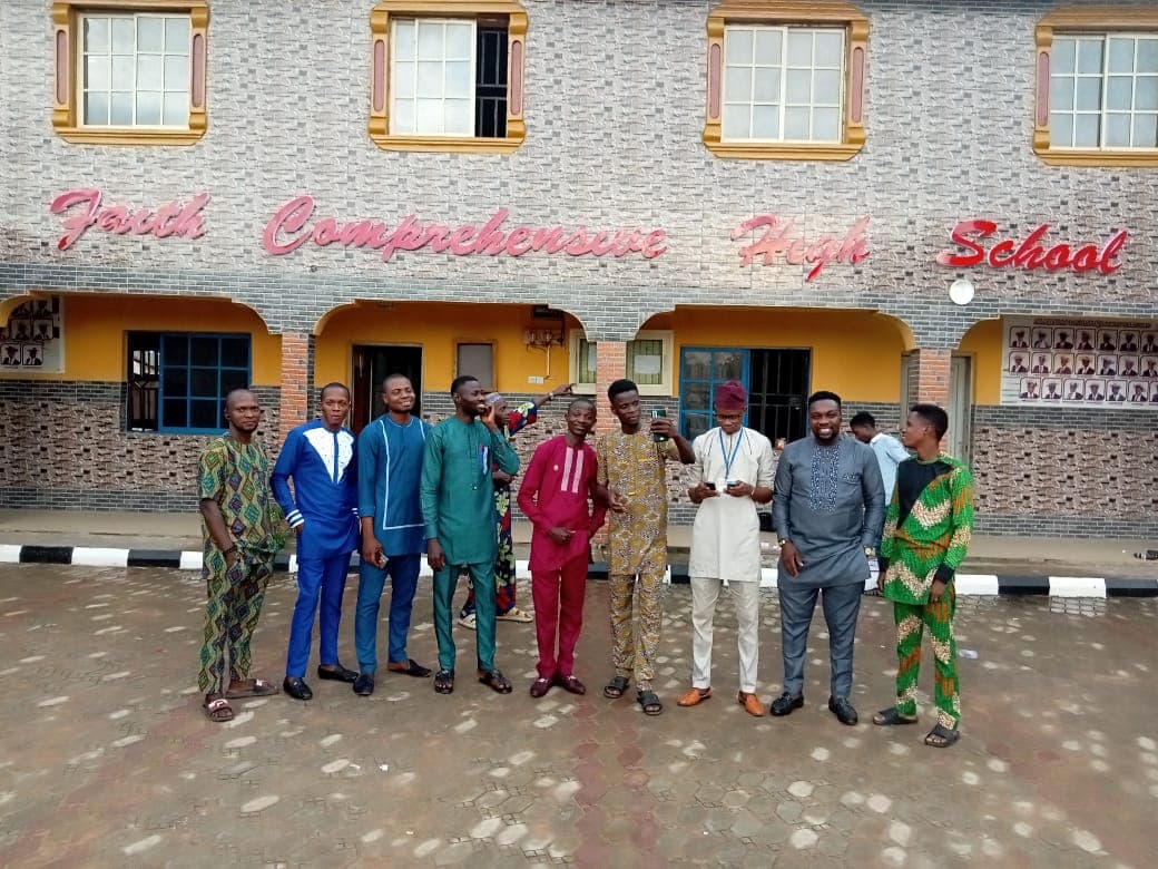 Students in traditional attire outside the school building